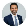Smiling man in a navy suit and tie from the Avenix contact team